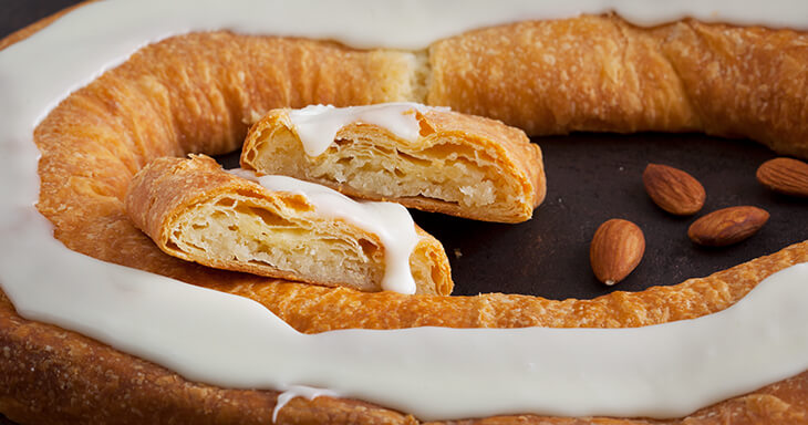 Traditional Danish Almond Kringle, a flaky pastry filled with almond cream and topped with icing, from Racine, Wisconsin.