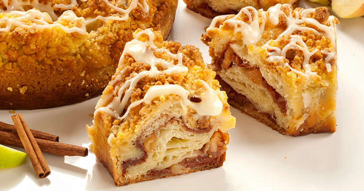 A delicious apple coffee cake featuring layers of cinnamon and apple goodness, made with Danish pastry, topped with crumbly streusel and creamy icing.