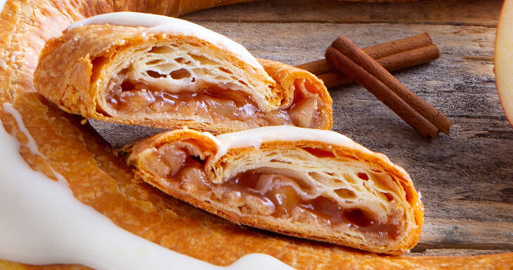 Apple Kringle showcasing the Danish pastry filled with a rich, homemade apple filling, featuring tender, cinnamon-sprinkled crisp apples that create a delightful blend of flavors.