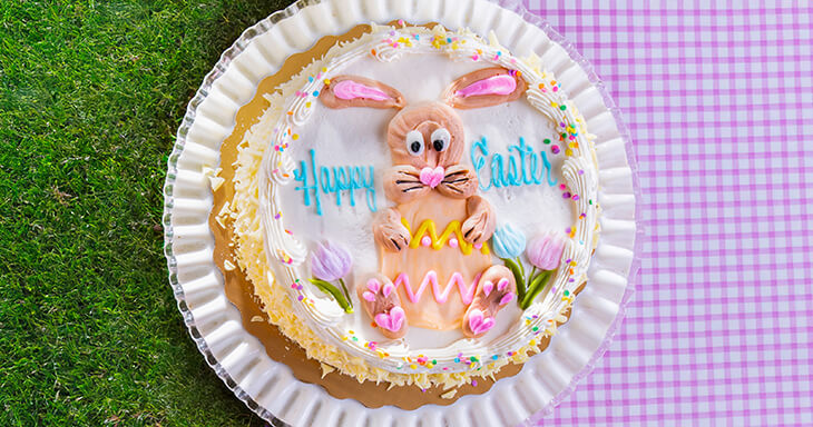 Colorful Easter Layer Cake with four bright layers, creamy buttercream, and fun Easter themed decorations. A festive treat for your Easter dessert table!