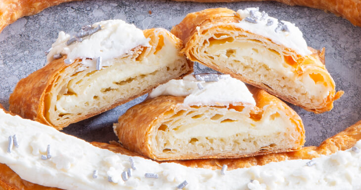 Our Christmas Kringle, a festive treat filled with cozy vanilla and a hint of citrus, topped with luscious vanilla bean frosting.