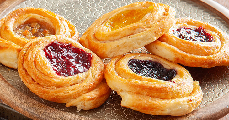 Assortment of no added sugar or salt Danish rolls with fruit toppings, perfect for any occasion.