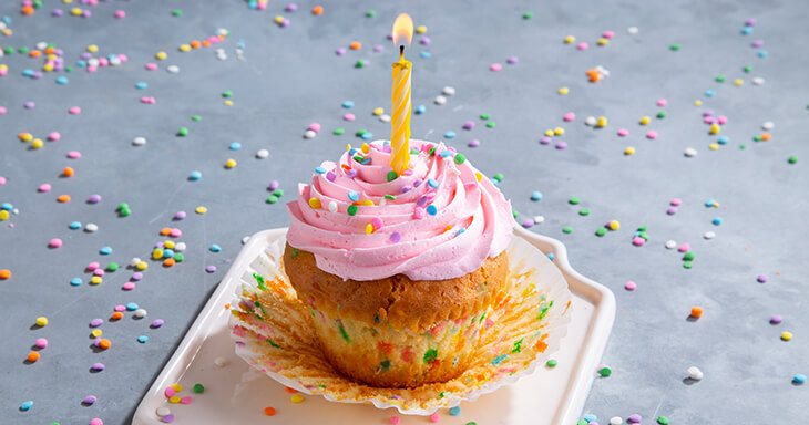 A rainbow sprinkle cupcake designed for birthdays, making a perfect gift option as a fun and festive birthday cake alternative.