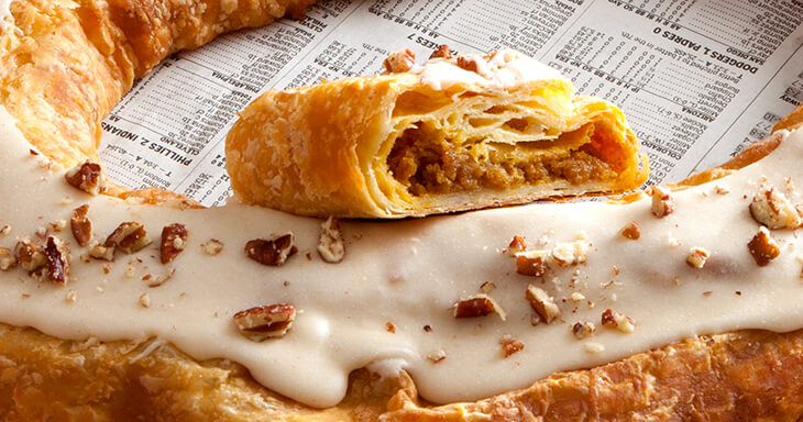 Pumpkin Caramel Kringle, showcasing its   rich blend of pumpkin, spices, and caramel, topped with pecans.