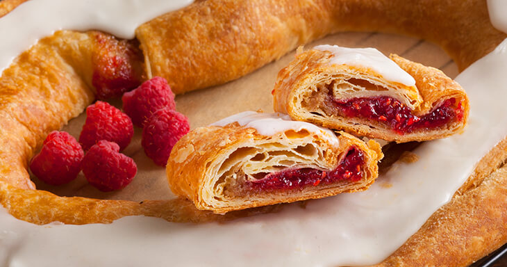 Our Danish Kringle, crafted with freshly picked ruby-red raspberries blended to perfection. Experience a delightful burst of sweetness in every bite of our Racine Kringle, a true treat for dessert lovers!