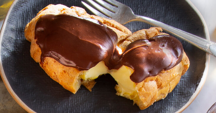 Traditional chocolate éclairs filled with velvety custard.