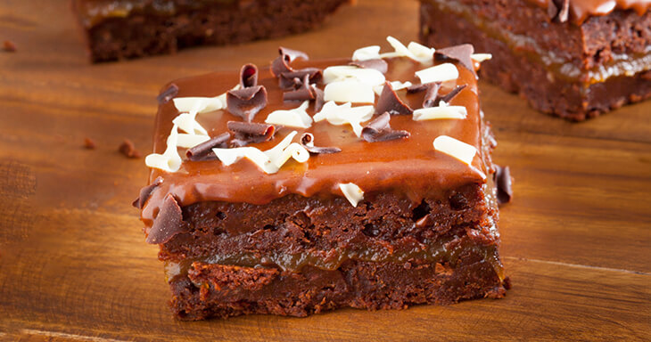 Fudge frosted triple layer brownies topped with chocolate curls.